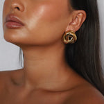 eivor earrings, gold bold, chunky statement piece with a triangular shape and a twisted looping knot-like design