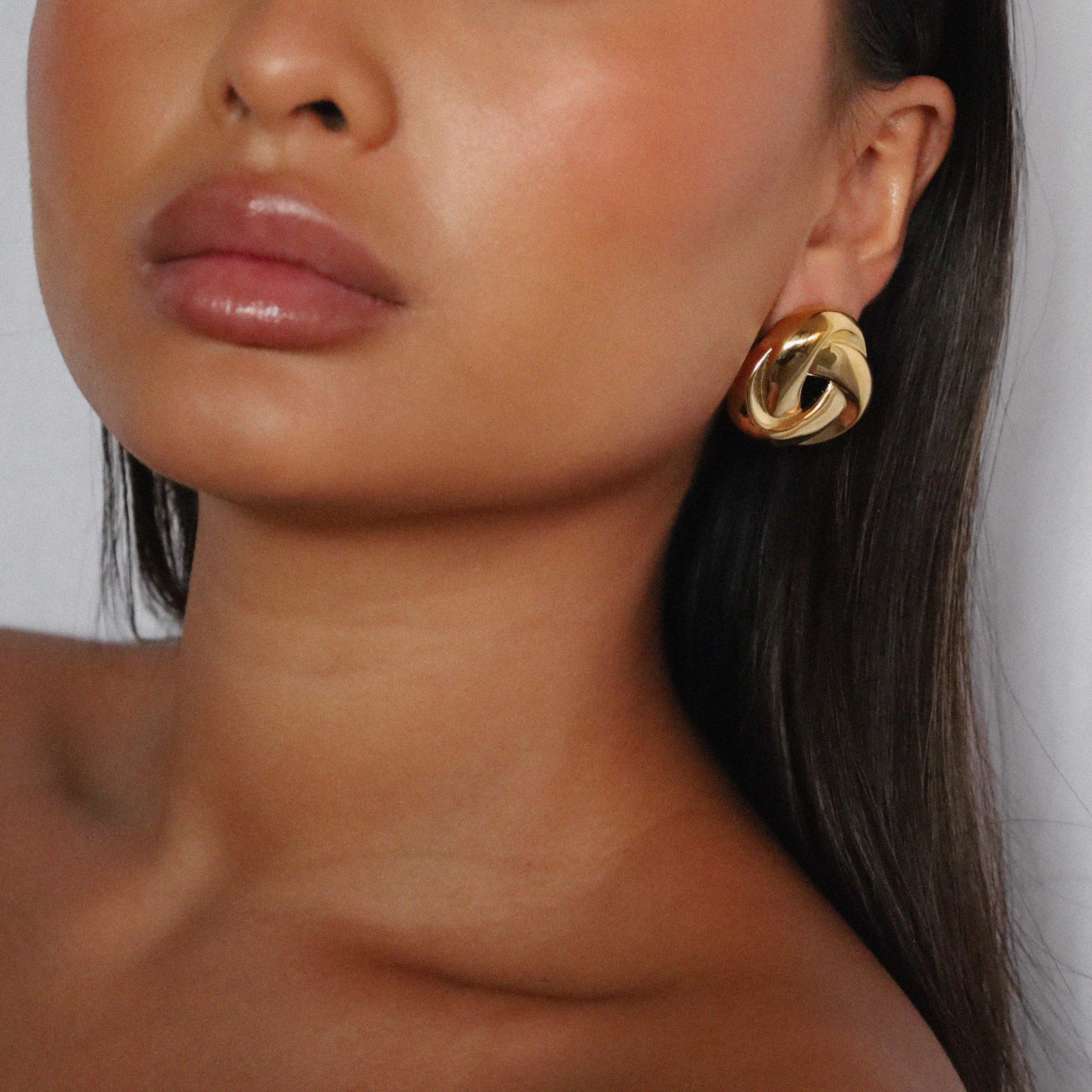 eivor earrings, gold bold, chunky statement piece with a triangular shape and a twisted looping knot-like design