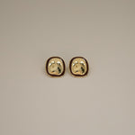 ekatt earrings, gold unique organic shape with a smooth, polished surface and subtle, engraved line designs with a wine red border