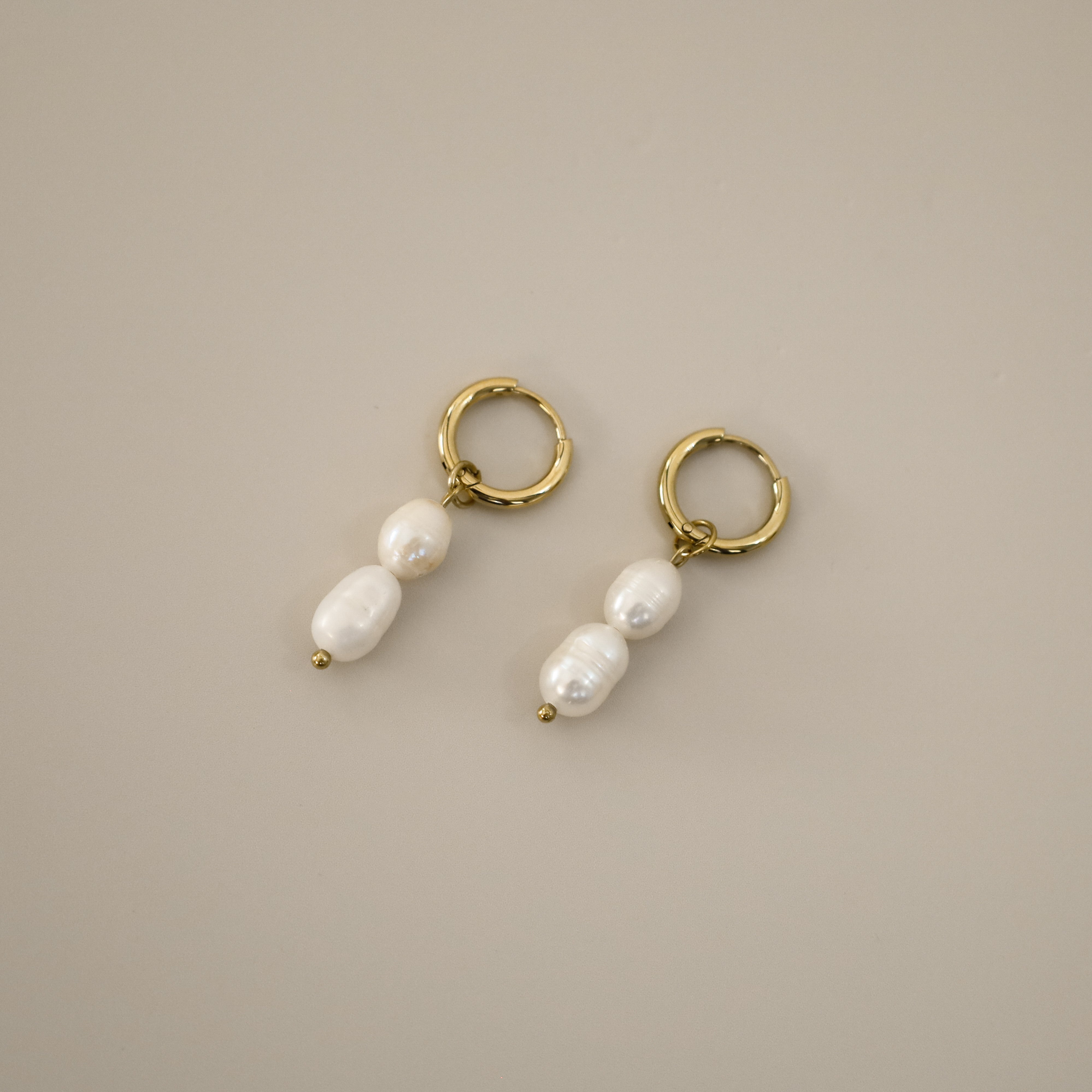 elissant earrings, two baroque freshwater pearls hanging from small gold latch back hoops