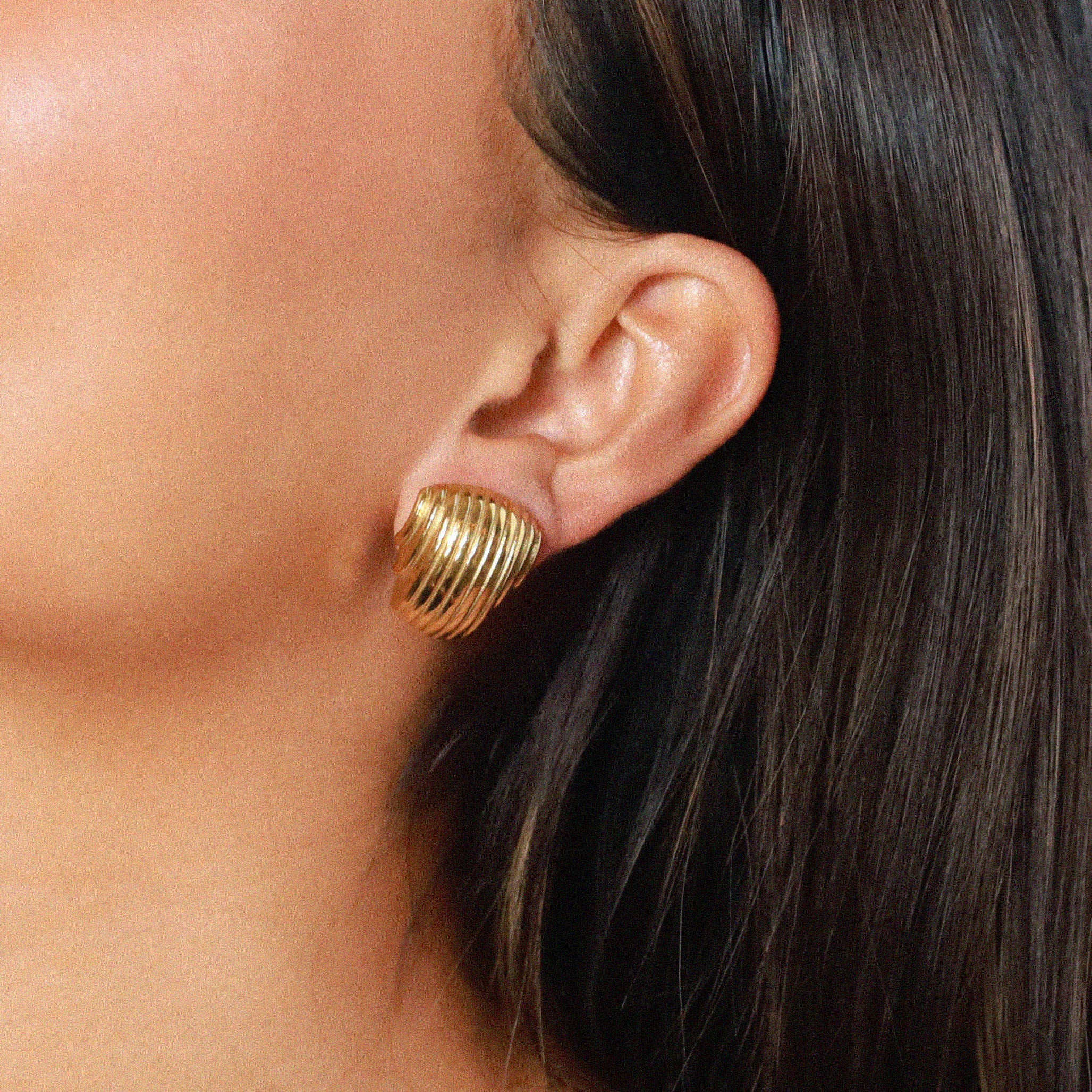 ewadi earrings, gold, distinctive staggered, layered design with a ribbed texture that wraps around in a curved, dome-like shape