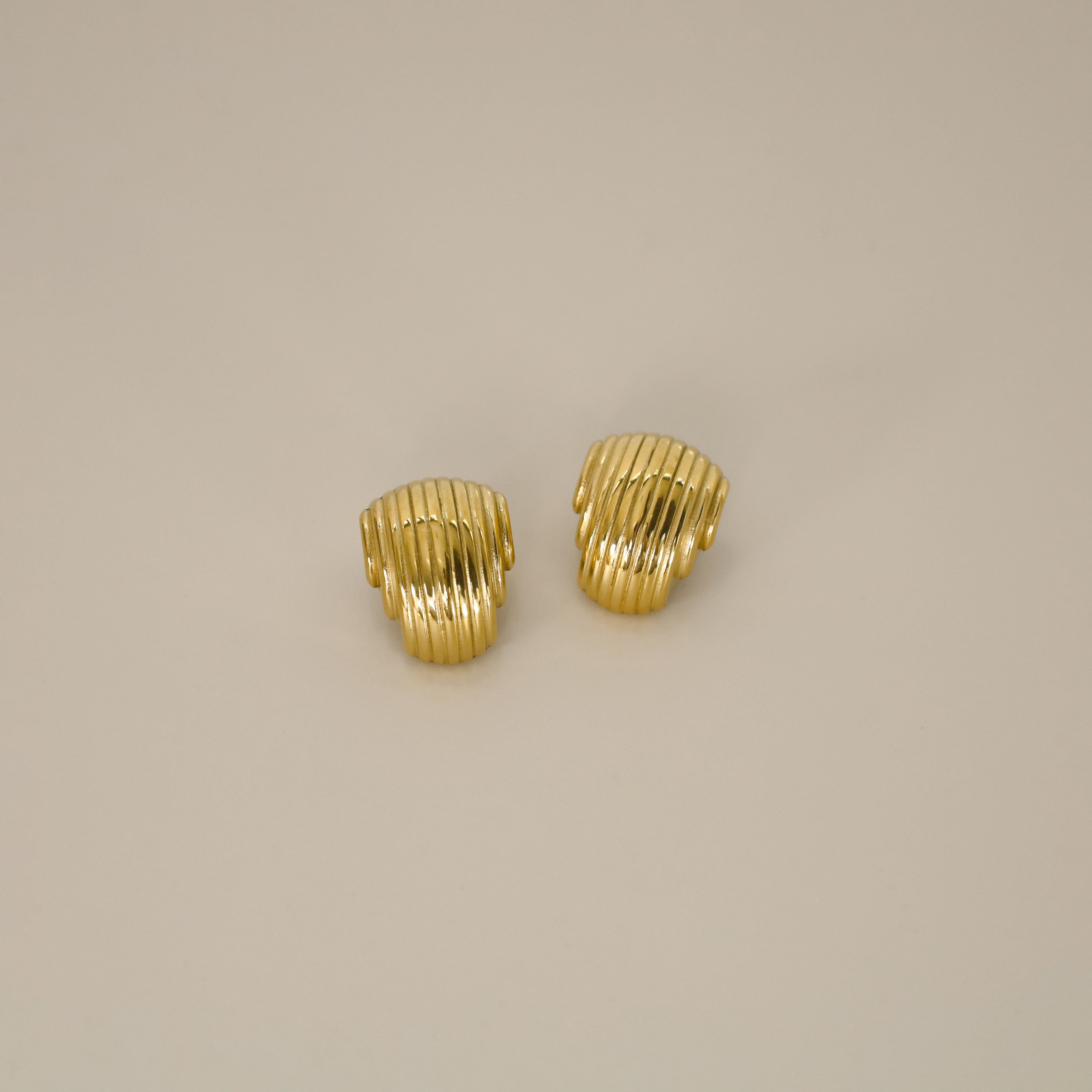 ewadi earrings, gold, distinctive staggered, layered design with a ribbed texture that wraps around in a curved, dome-like shape