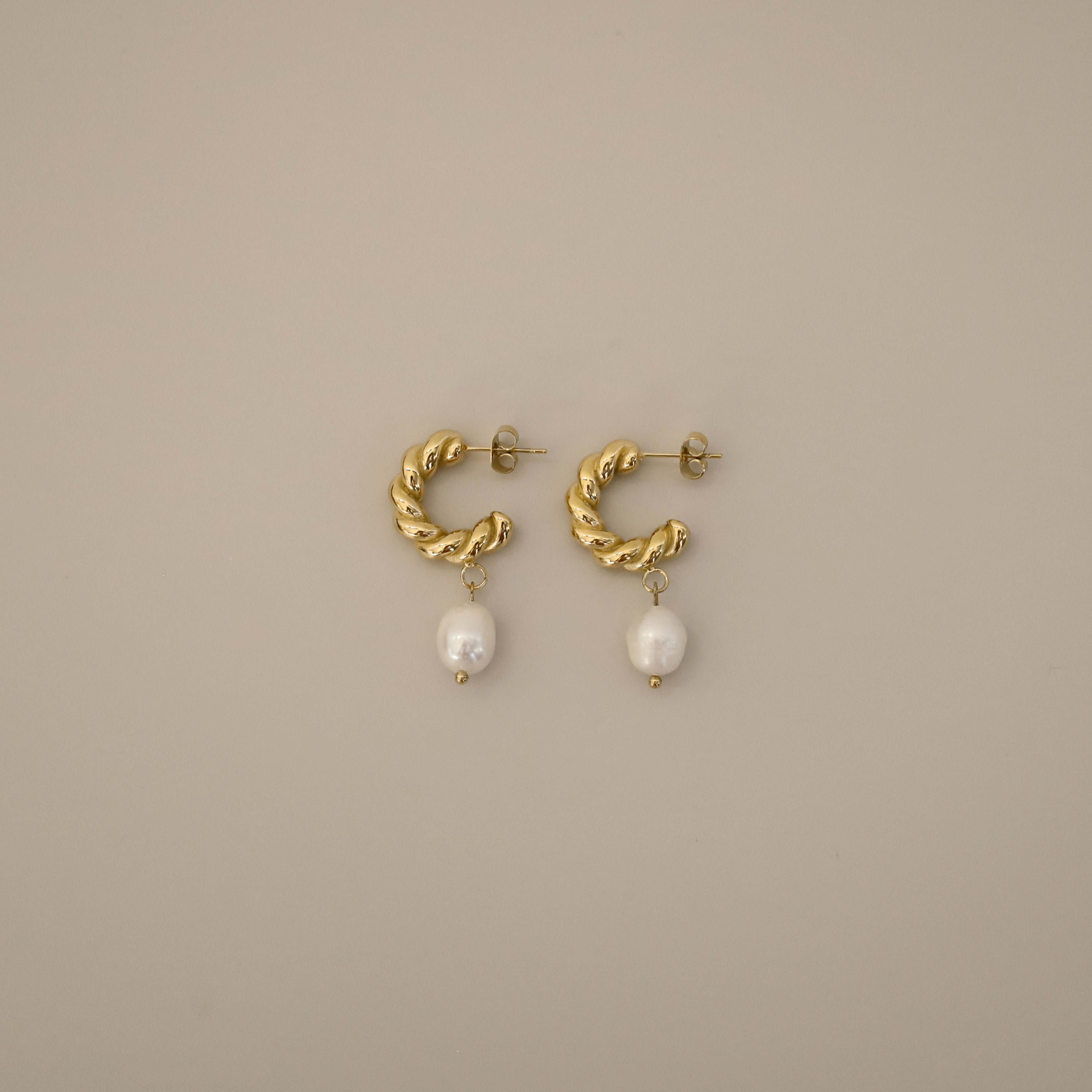 eharli earrings, twisted gold hoop design accented by a single dangling freshwater pearl