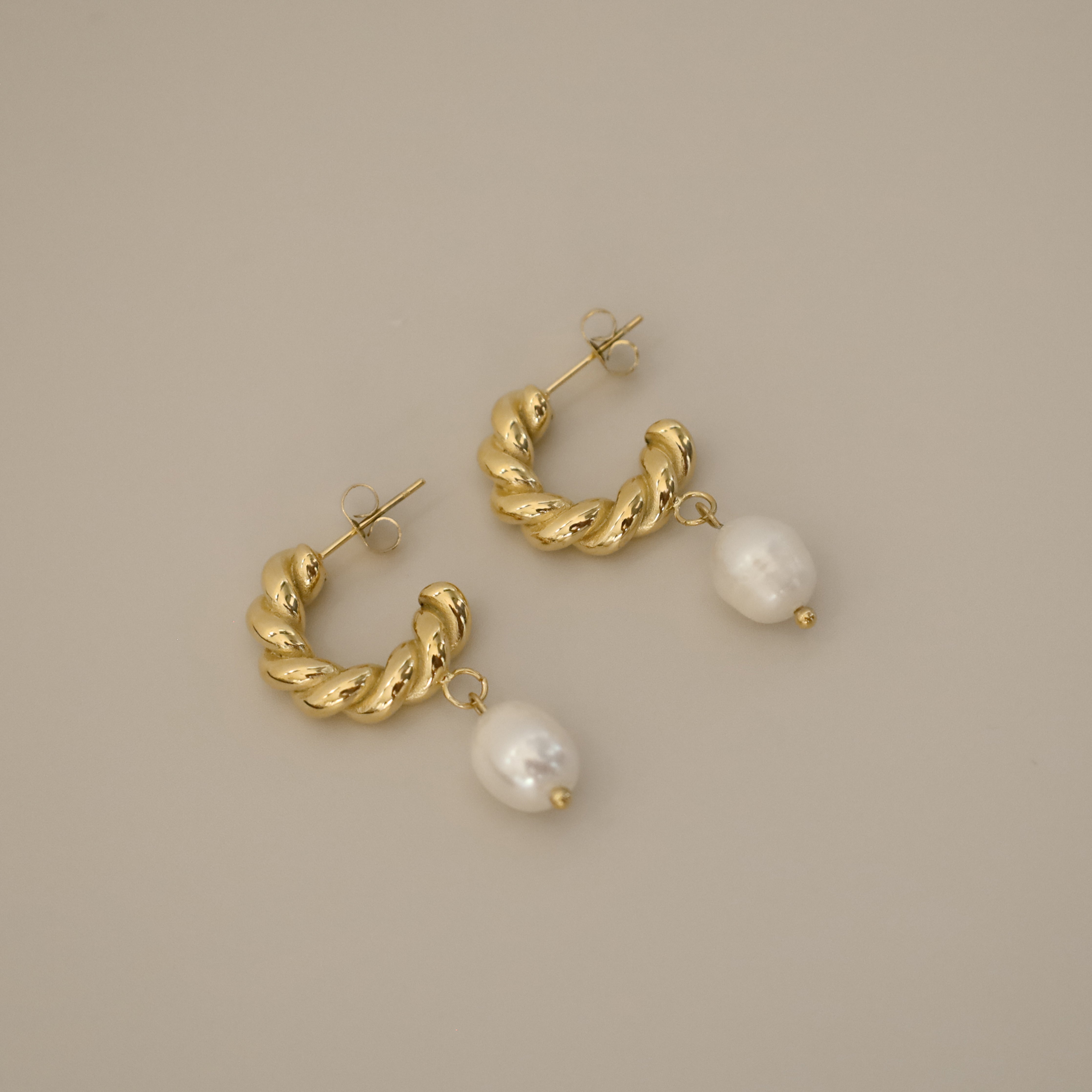 eharli earrings, twisted gold hoop design accented by a single dangling freshwater pearl