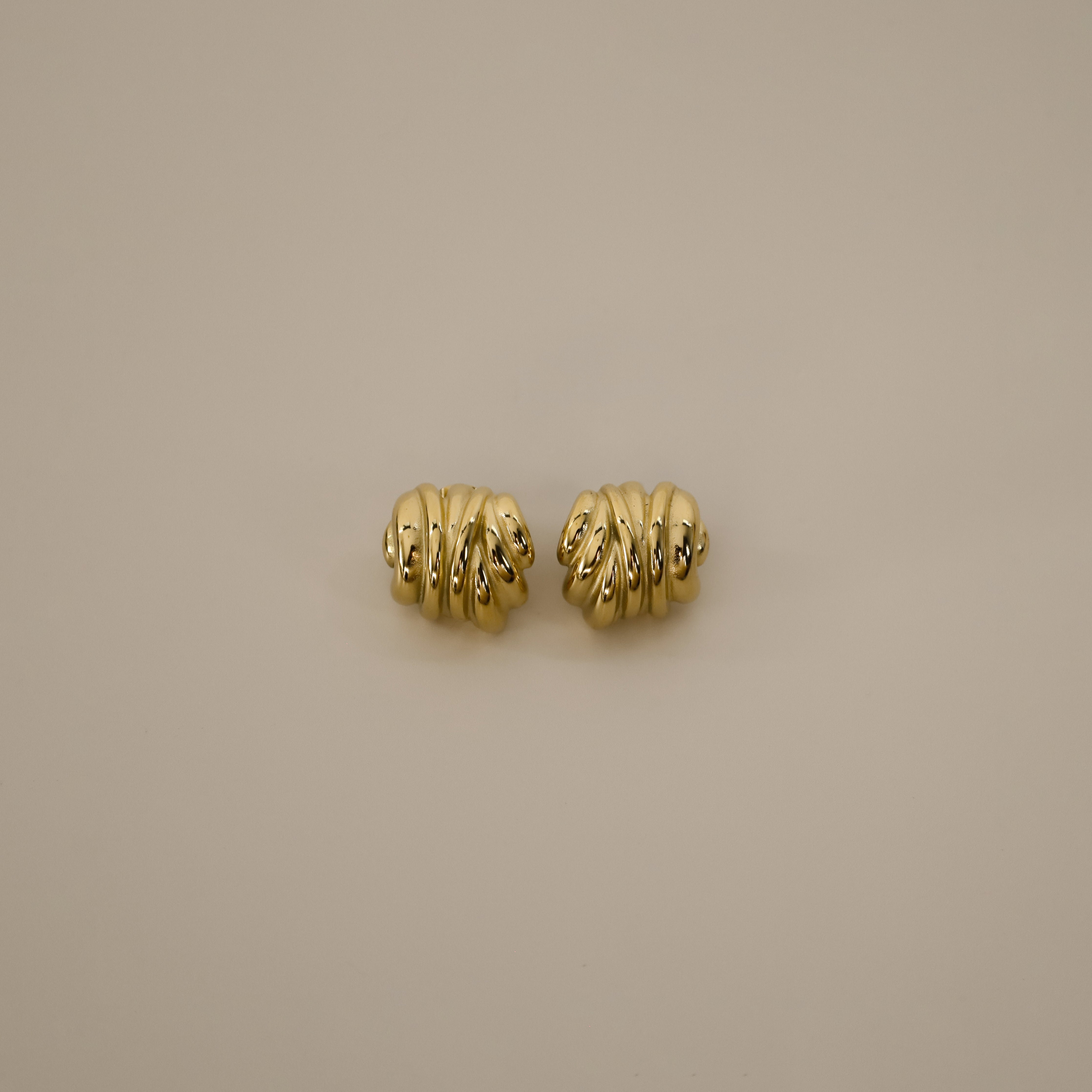 ekene earrings, gold chunky bold hoop earrings that feature multiple rounded overlapping layers creating a stacked, textured appearance