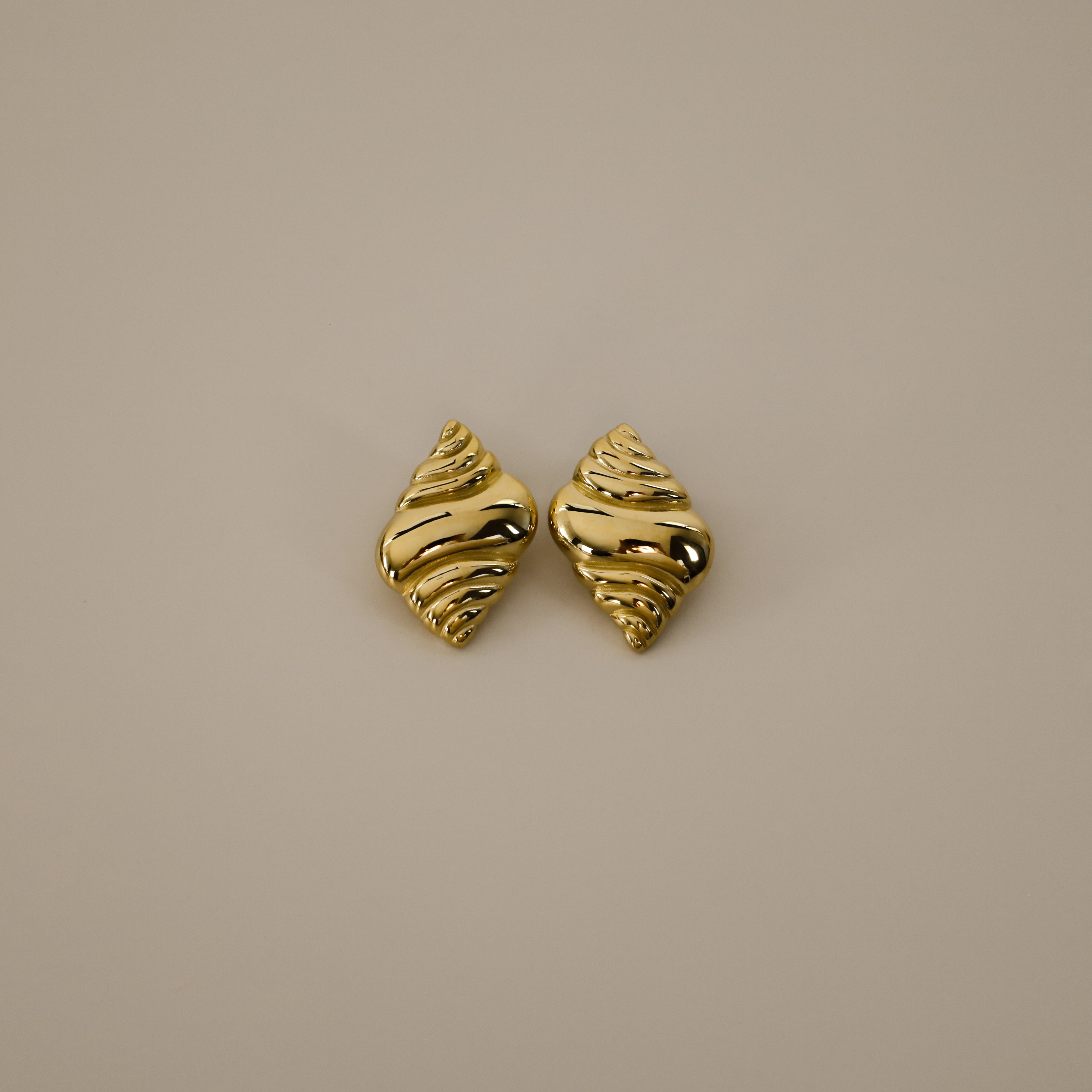 ekrossi earrings, gold curved shape and smooth, rippled surface, similar to a croissant,