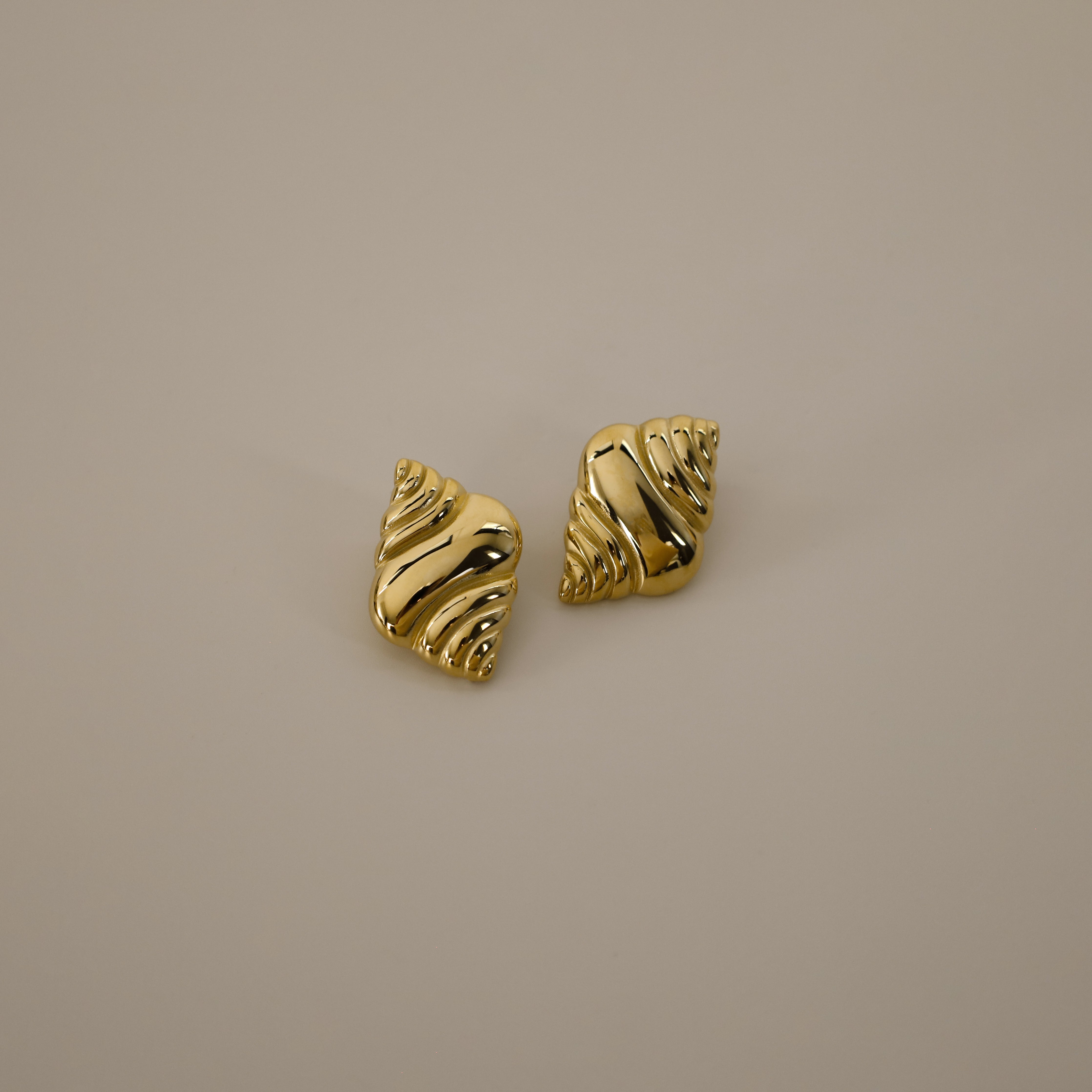 ekrossi earrings, gold curved shape and smooth, rippled surface, similar to a croissant,