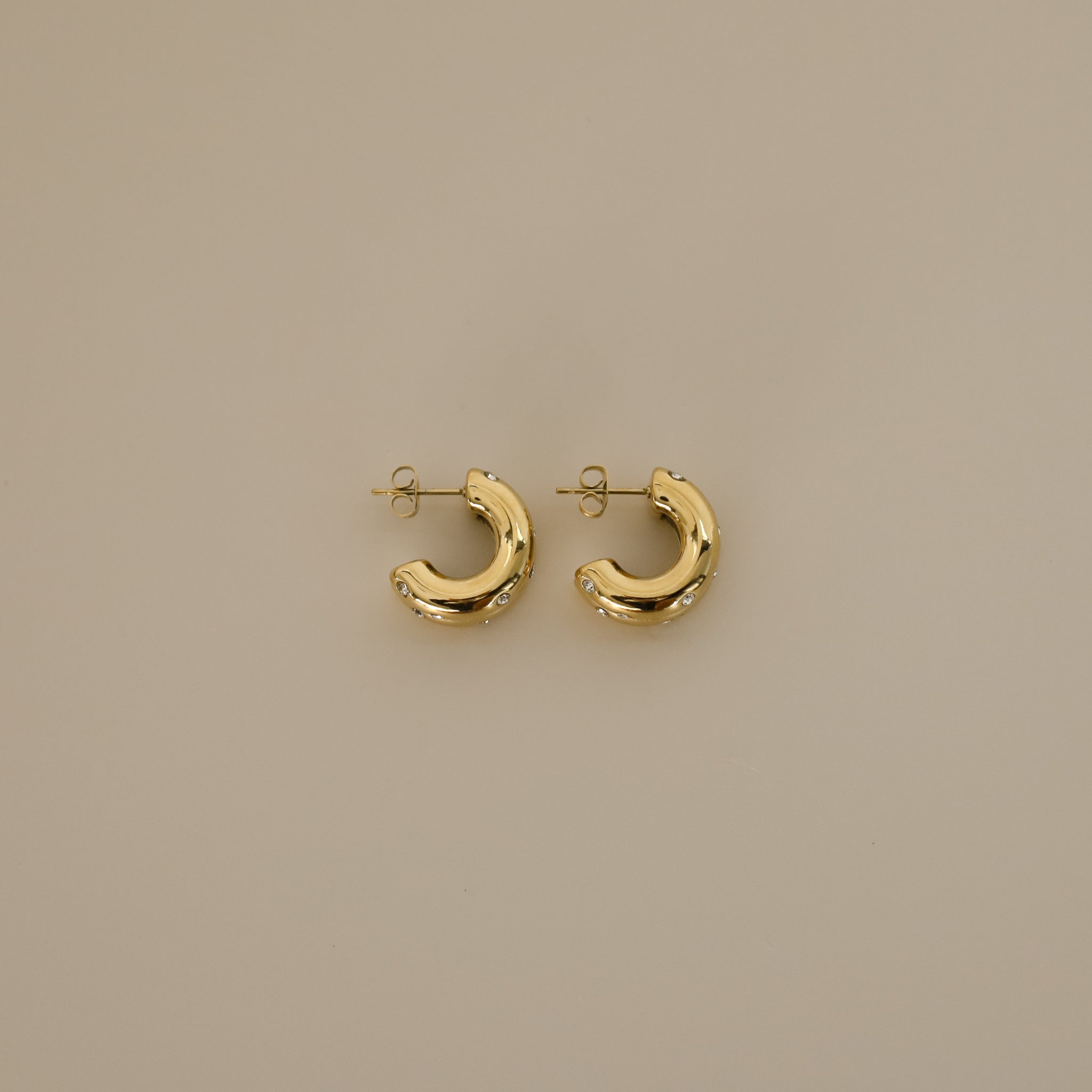 elidi earrings, gold bold double hoop earrings adorned with delicate, sparkling Cubic Zirconia stones sprinkled throughout