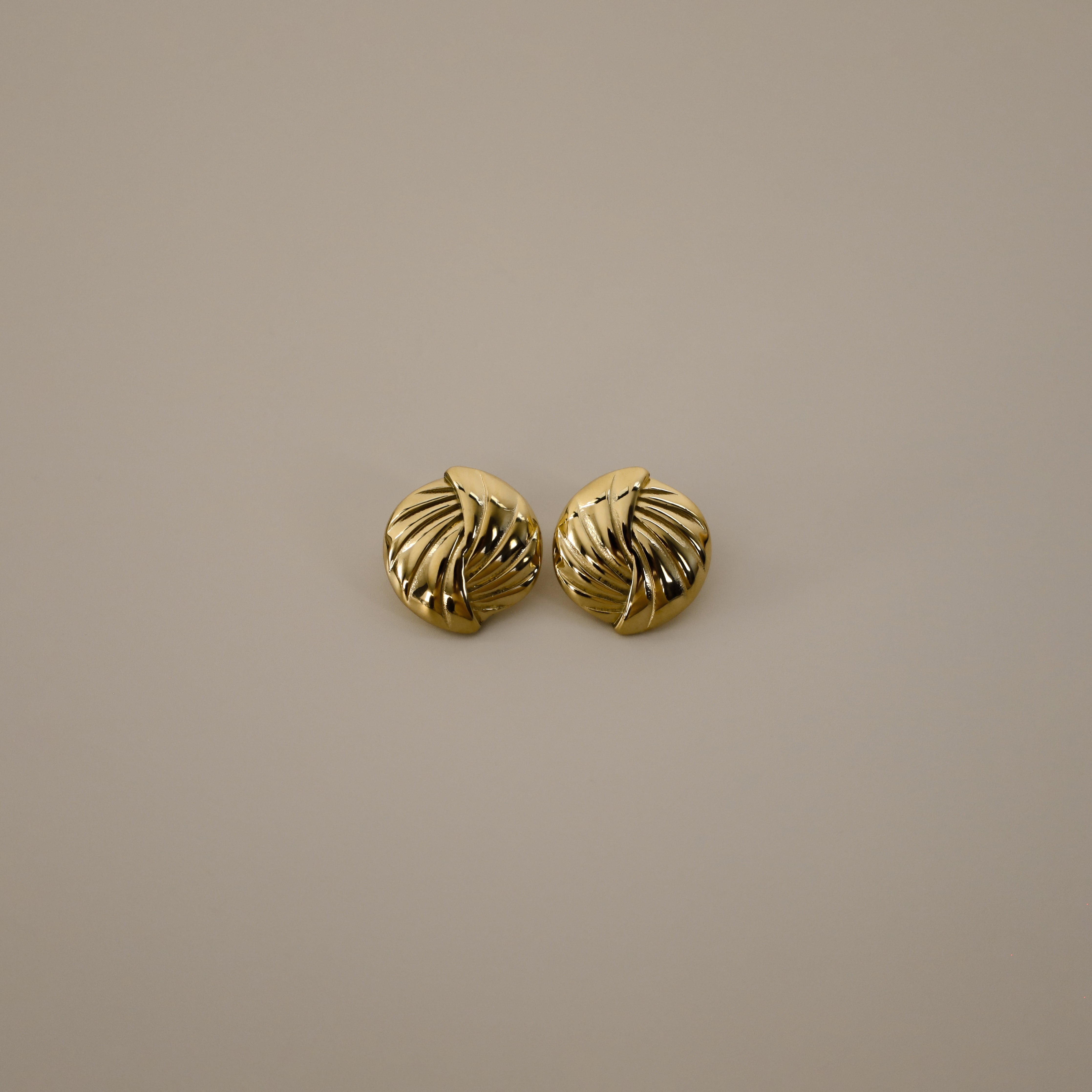 eppera earrings, gold circular design with a beautifully ribbed pattern that swirls around the surface