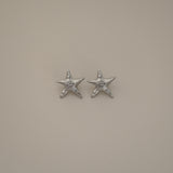 estarlin earrings, silver irregular medium star-shaped studs with a whimsical design. Each earring features a raised swirl at the center and touches of irregular textures placed throughout