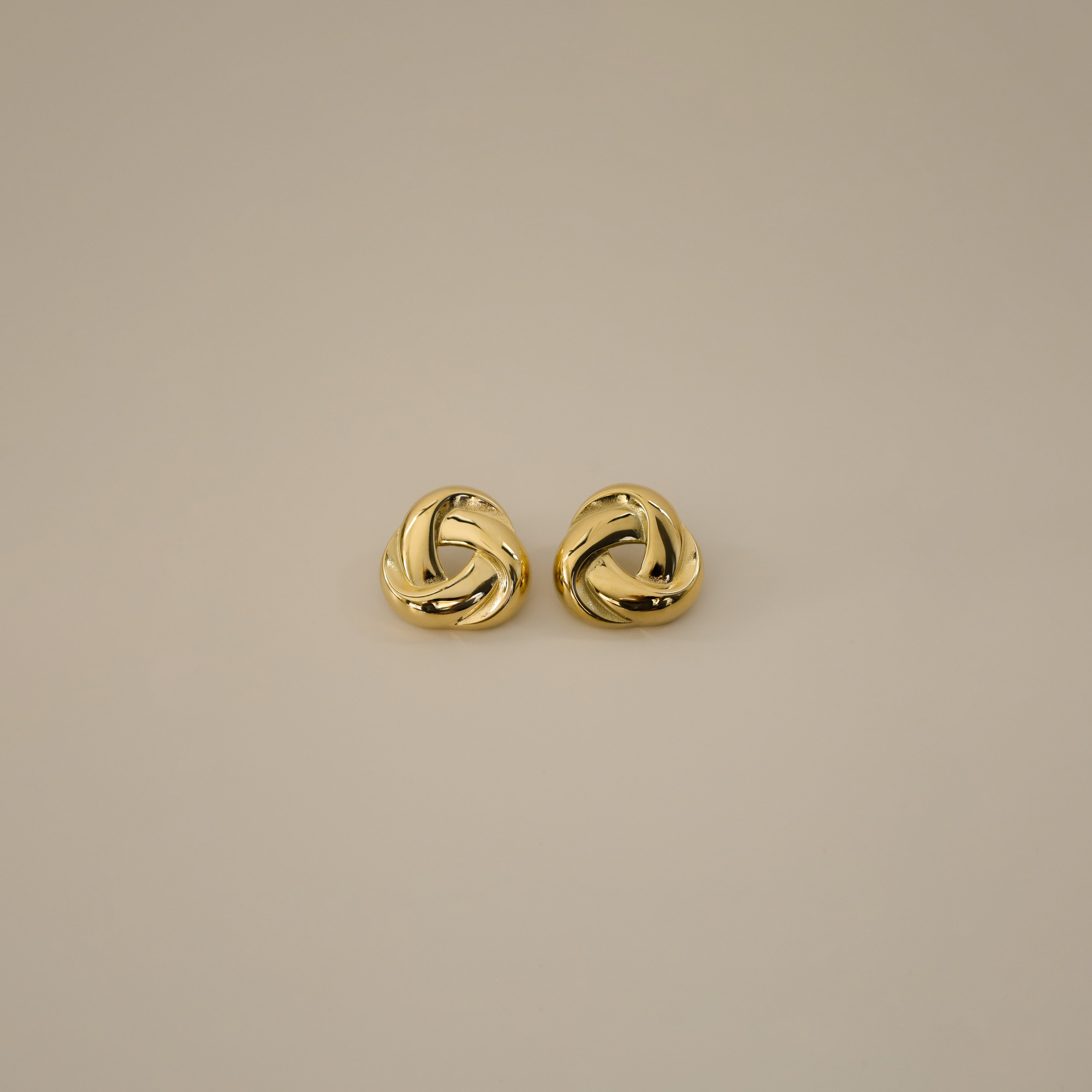 eivor earrings, gold bold, chunky statement piece with a triangular shape and a twisted looping knot-like design