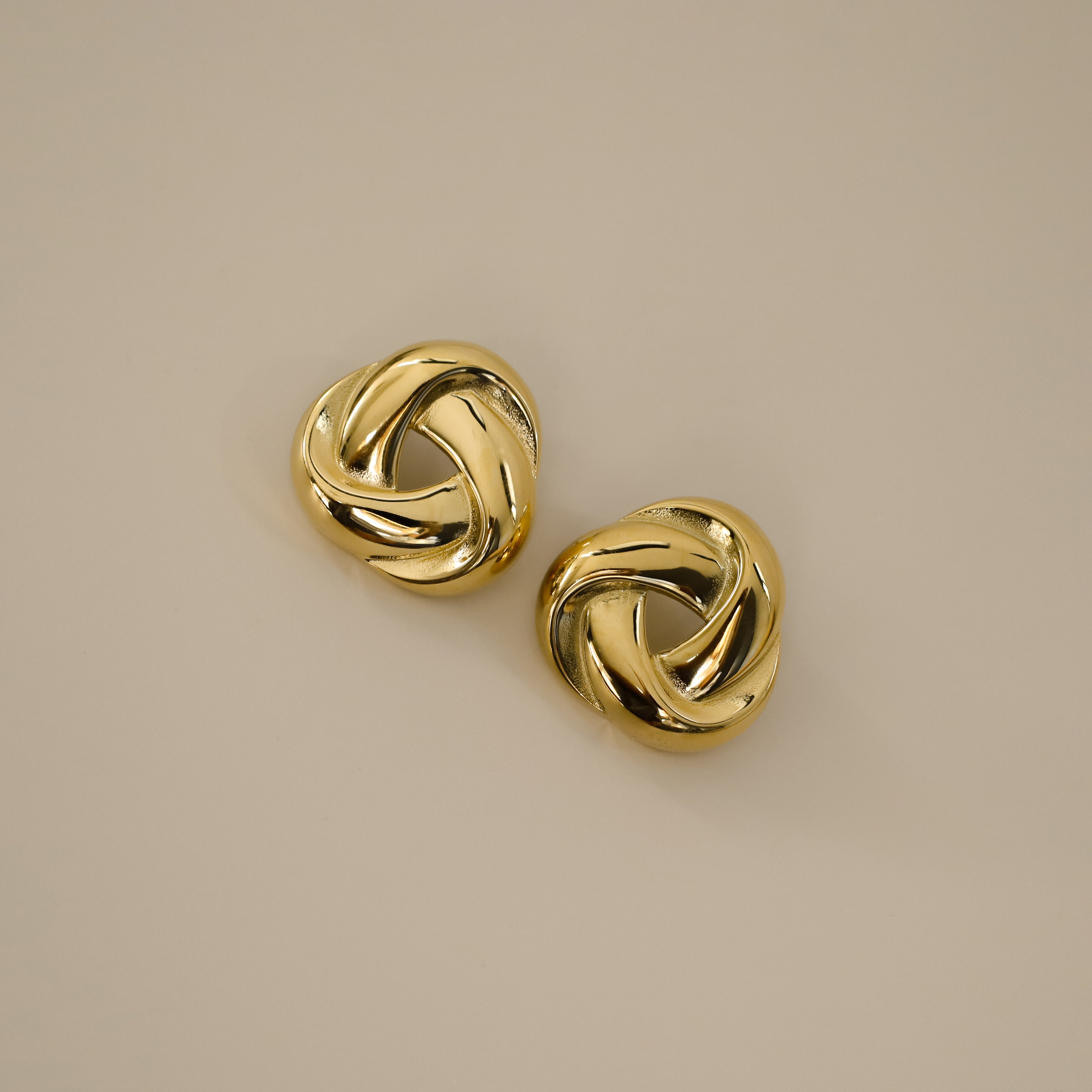 eivor earrings, gold bold, chunky statement piece with a triangular shape and a twisted looping knot-like design