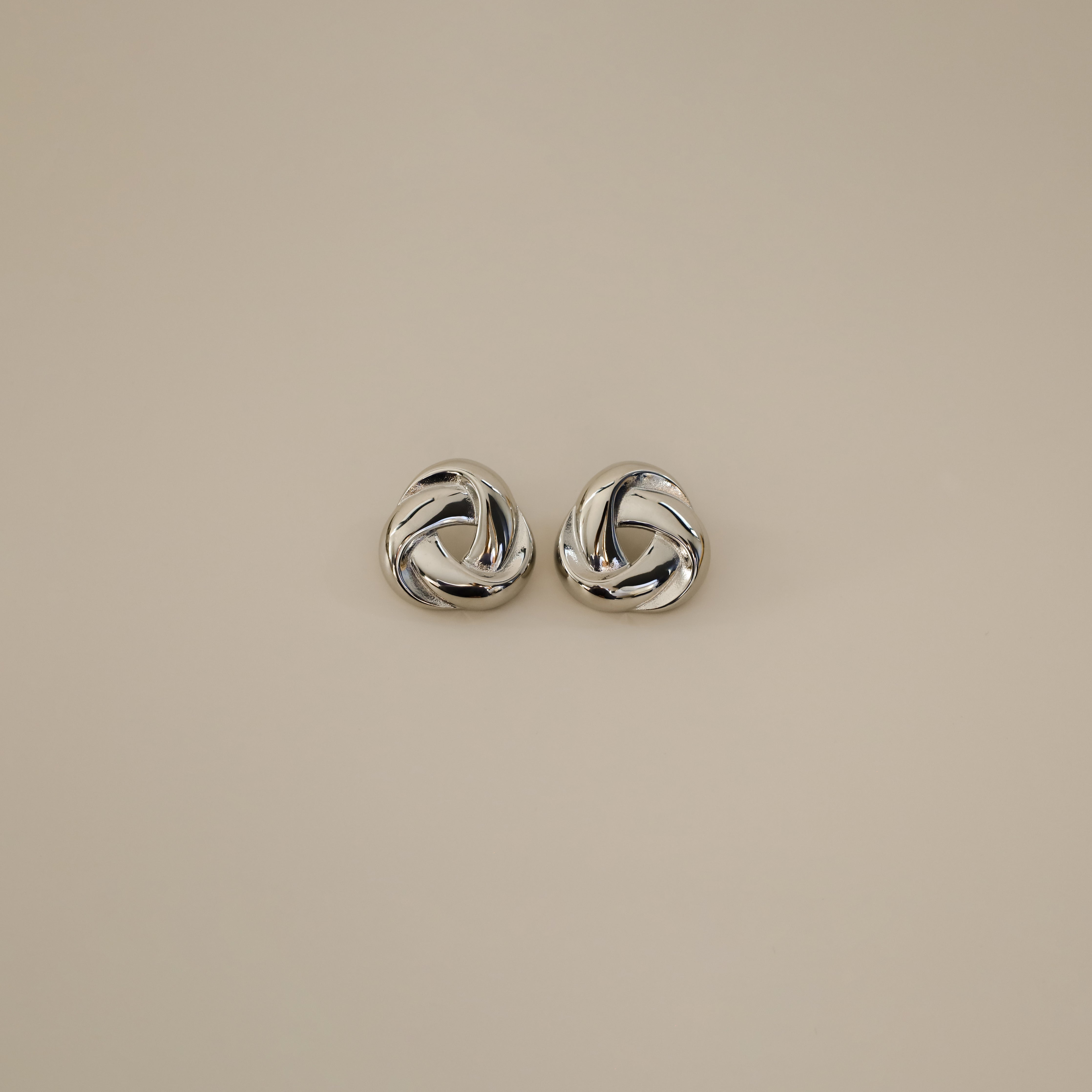 eivor earrings, silver bold, chunky statement piece with a triangular shape and a twisted looping knot-like design