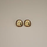 ekatt earrings, gold unique organic shape with a smooth, polished surface and subtle, engraved line designs with a wine red border