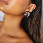 ekatt earrings, silver unique organic shape with a smooth, polished surface and subtle, engraved line designs with a dark wine red border