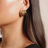 ekene earrings, gold chunky bold hoop earrings that feature multiple rounded overlapping layers creating a stacked, textured appearance