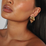 ekrossi earrings, gold curved shape and smooth, rippled surface, similar to a croissant,