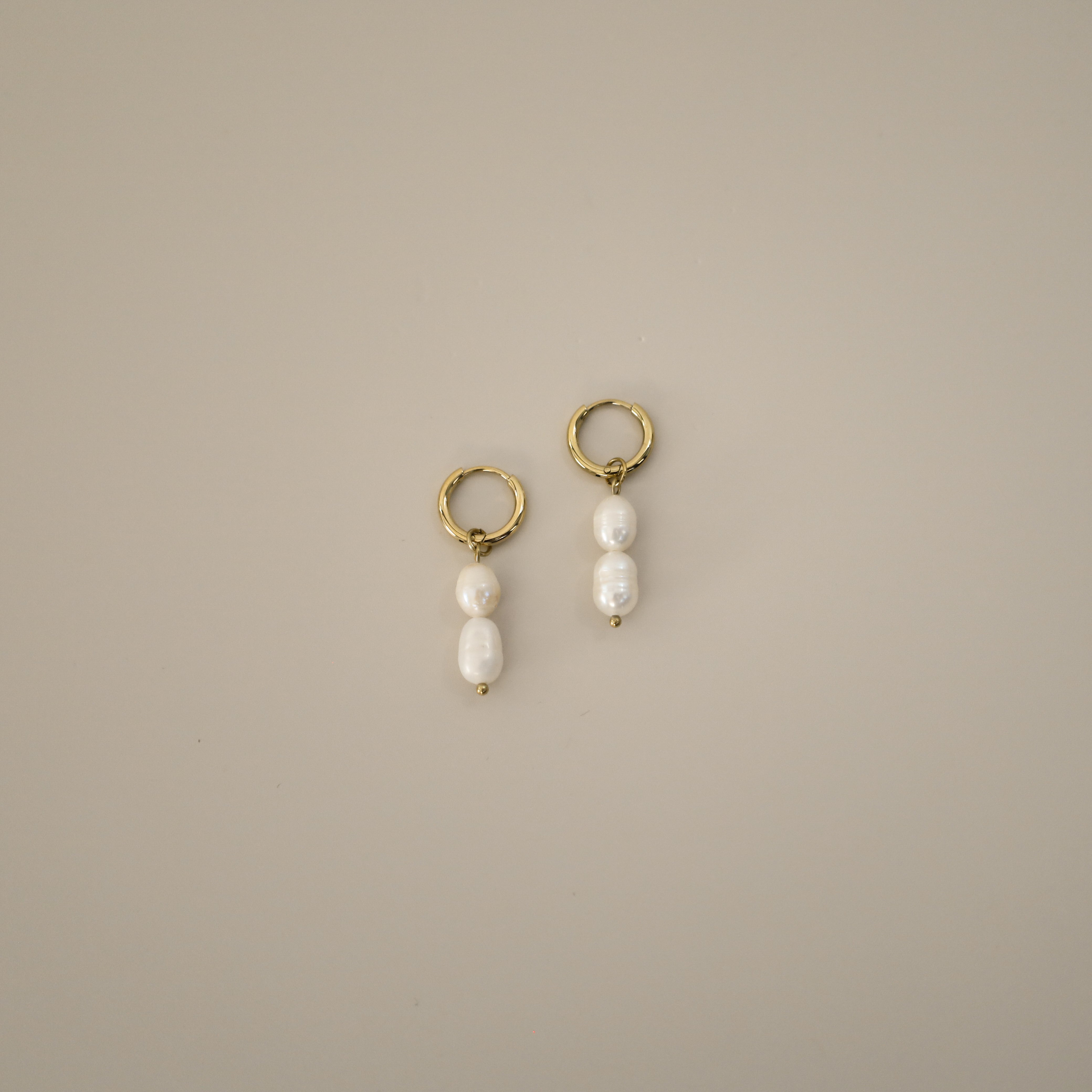 elissant earrings, two baroque freshwater pearls hanging from small gold latch back hoops