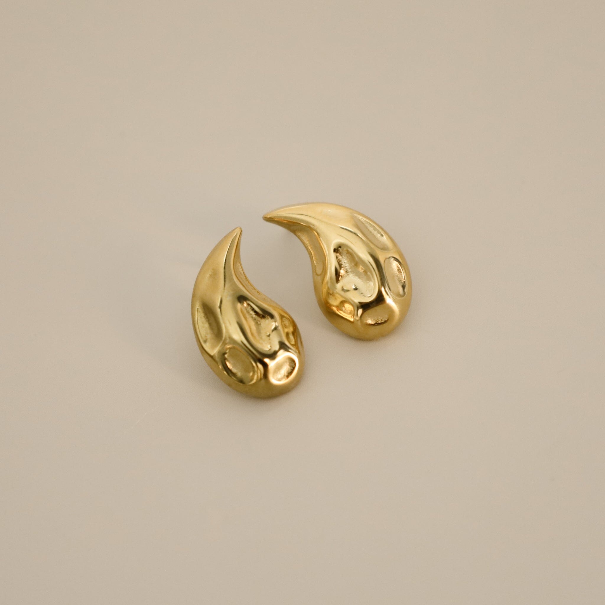 elwood gold earrings, small stud earrings featuring a curved teardrop shape with an irregular texture