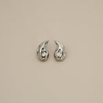 elwood silver earrings, small stud earrings featuring a curved teardrop shape with an irregular texture