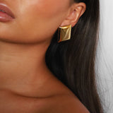 evrim earrings, gold bold rectangle design with a smooth domed surface