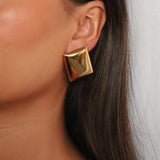 evrim earrings, gold bold rectangle design with a smooth domed surface