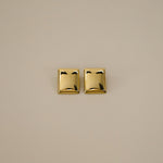 evrim earrings, gold bold rectangle design with a smooth domed surface