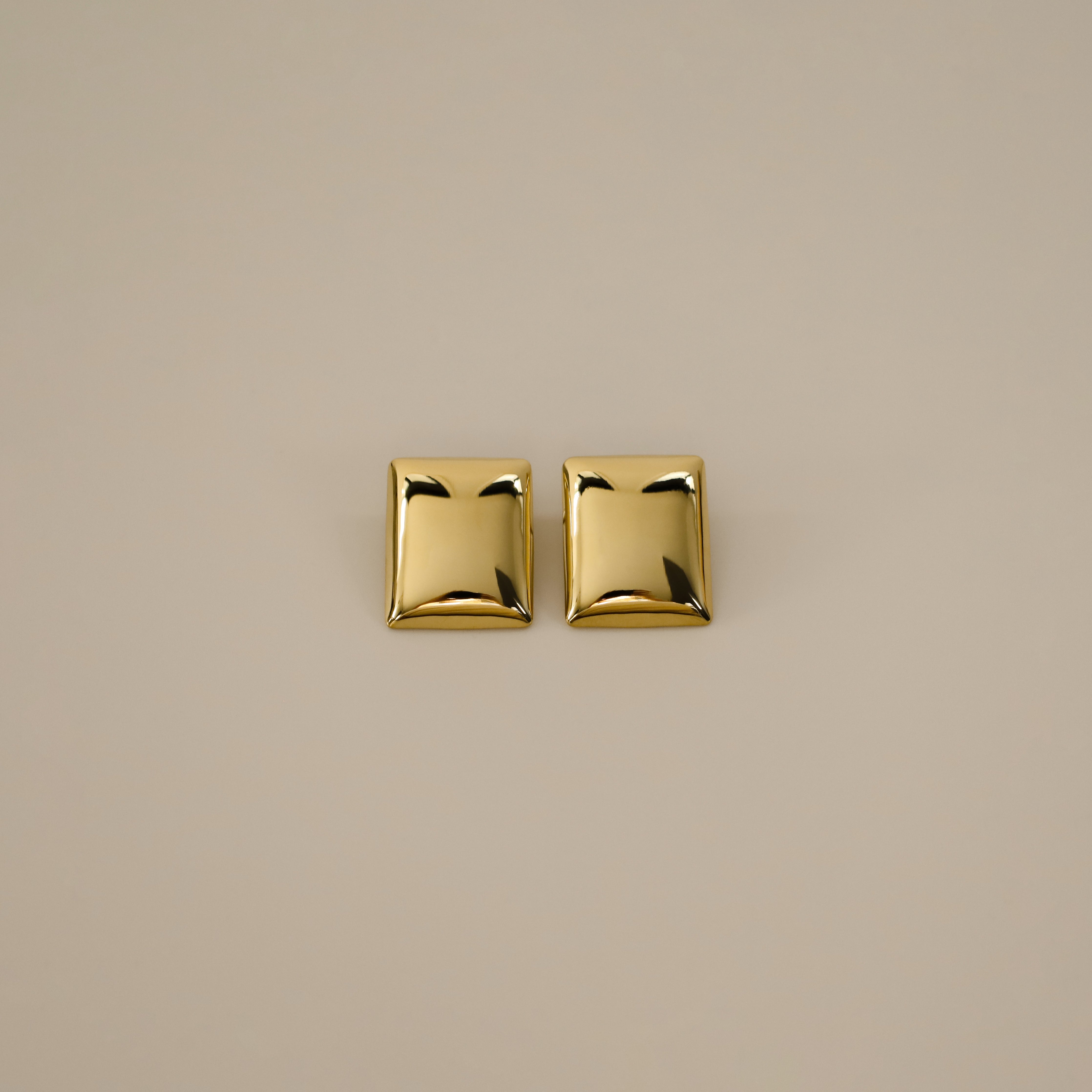 evrim earrings, gold bold rectangle design with a smooth domed surface