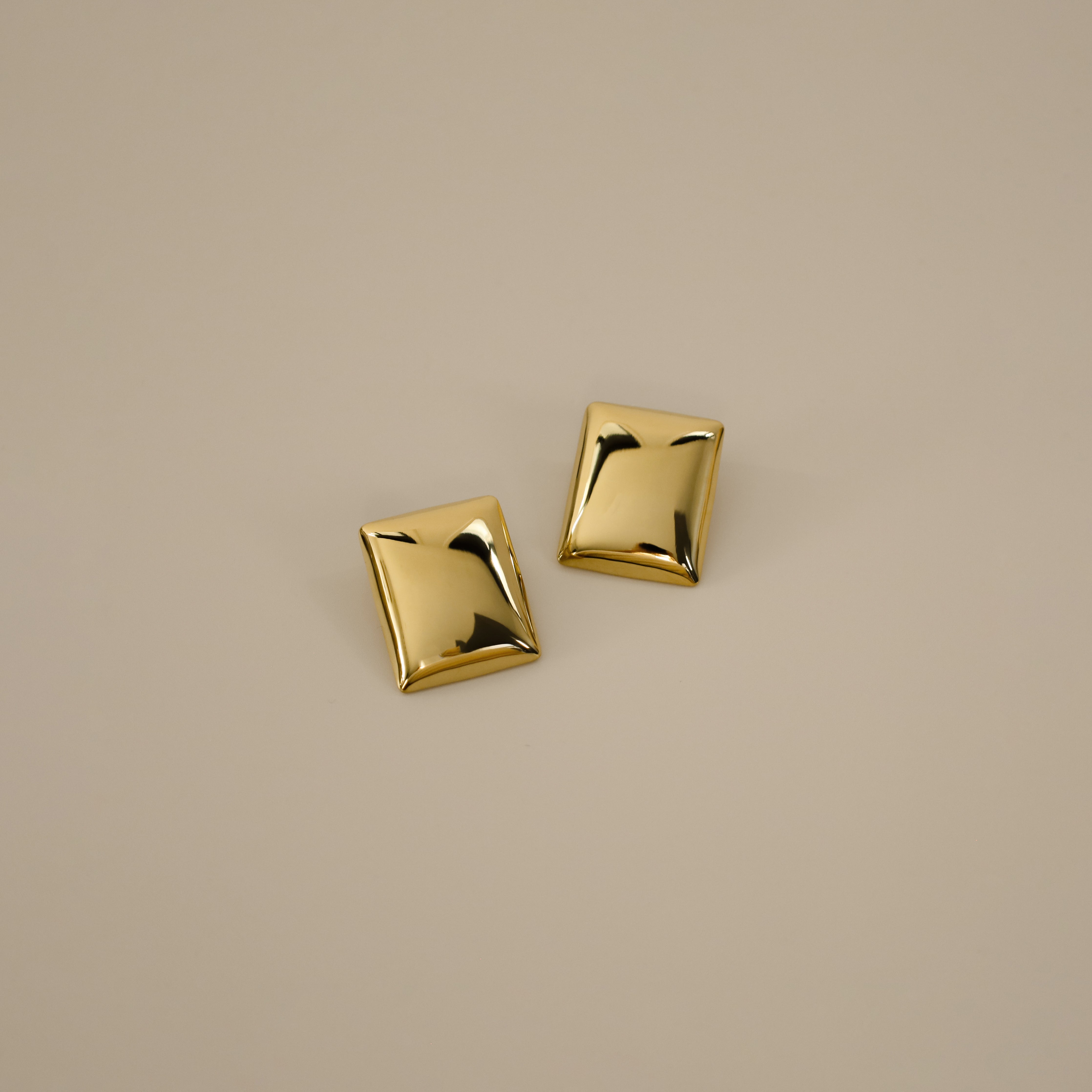 evrim earrings, gold bold rectangle design with a smooth domed surface