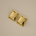 evrim earrings, gold bold rectangle design with a smooth domed surface