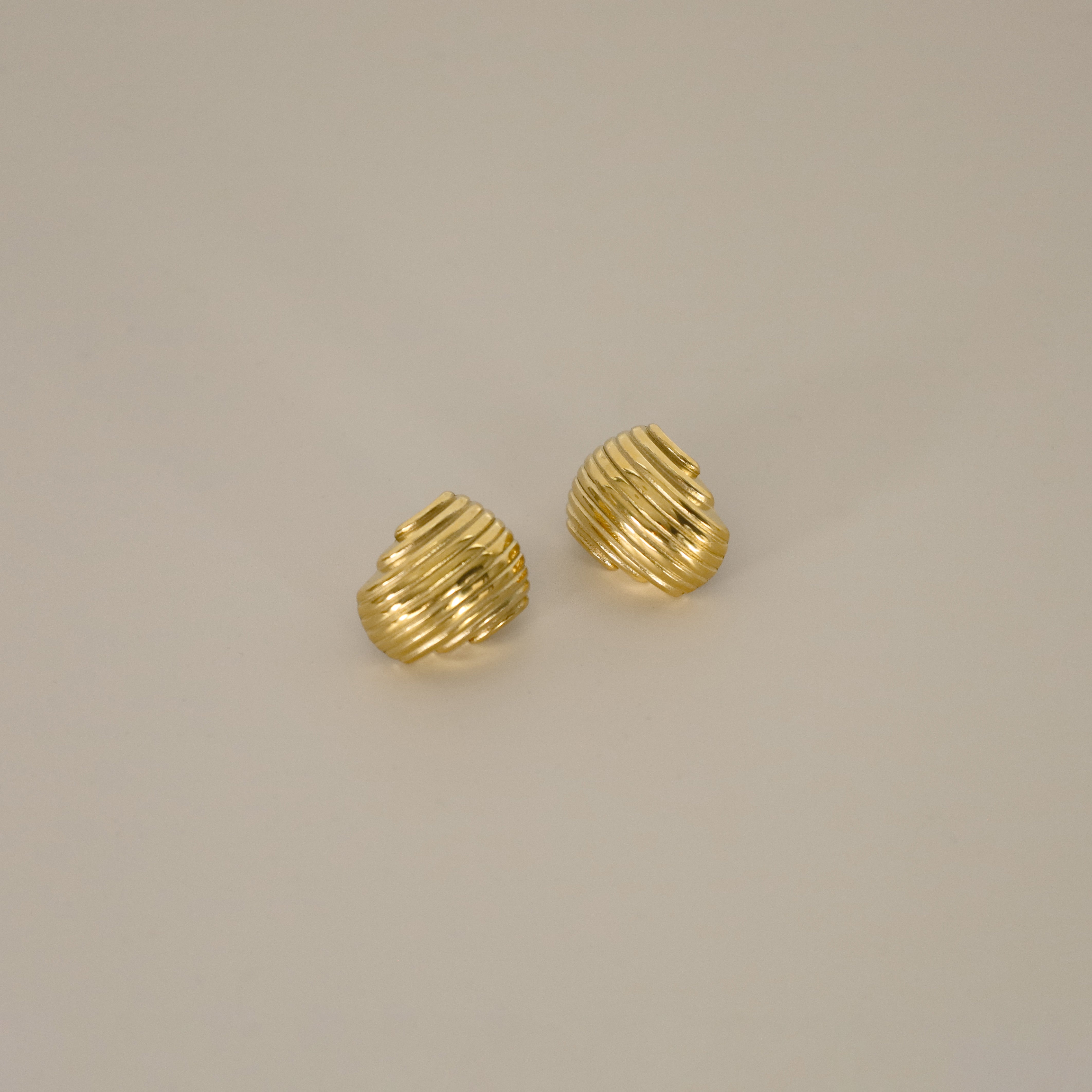 ewadi earrings, gold, distinctive staggered, layered design with a ribbed texture that wraps around in a curved, dome-like shape