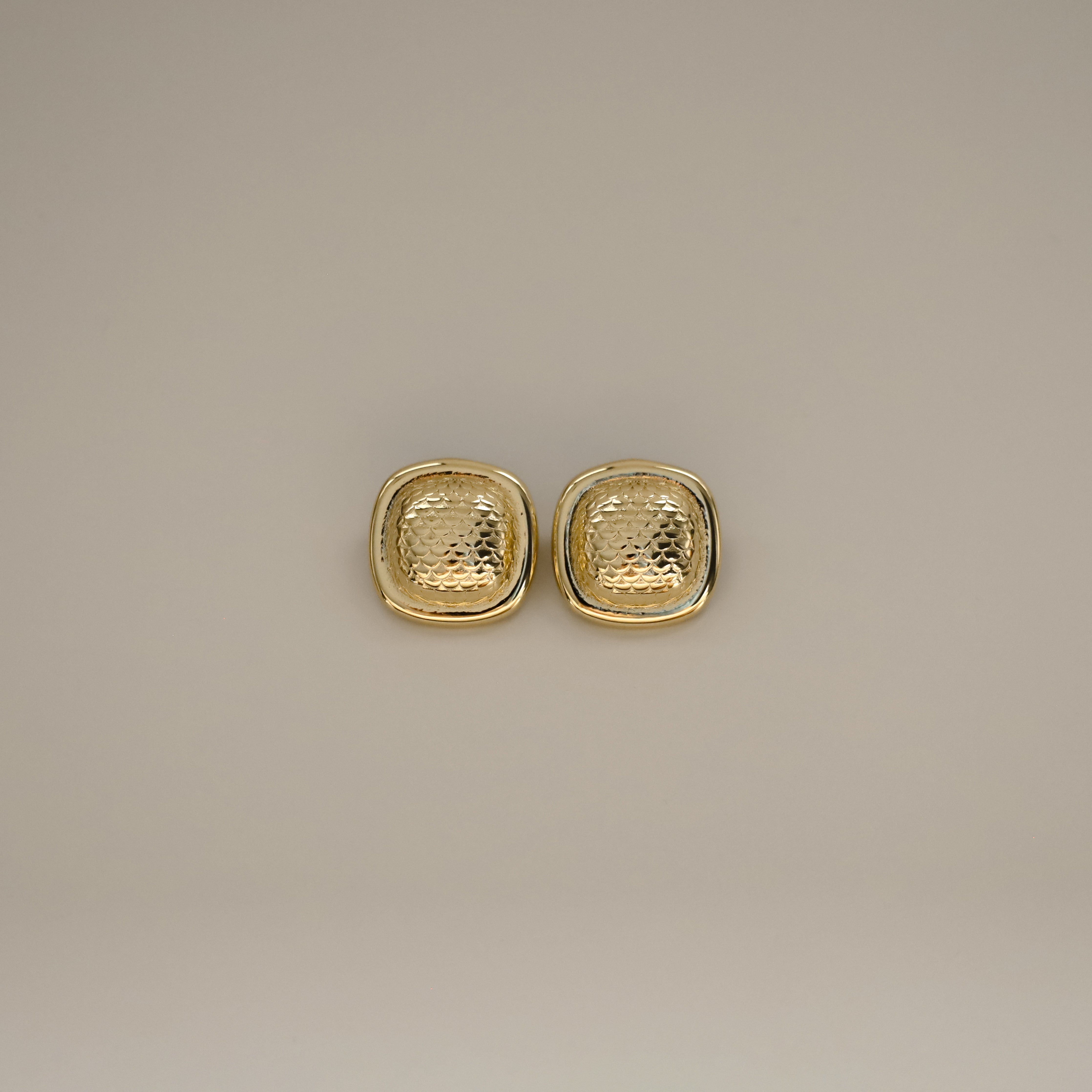 ezana earrings, gold rectangular earrings with puffy center in a scale design and smooth outer edge