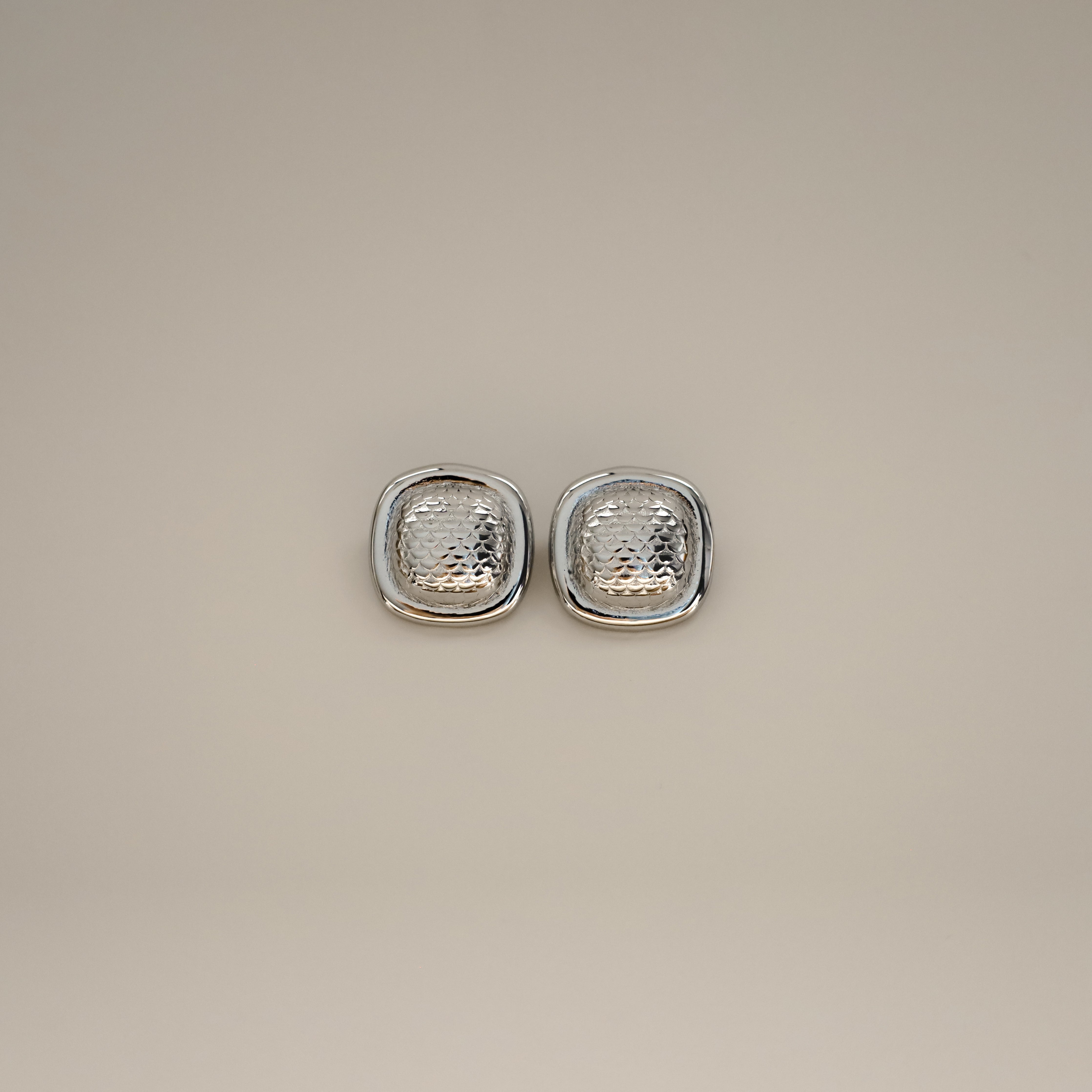 ezana earrings, silver rectangular earrings with puffy center in a scale design and smooth outer edge