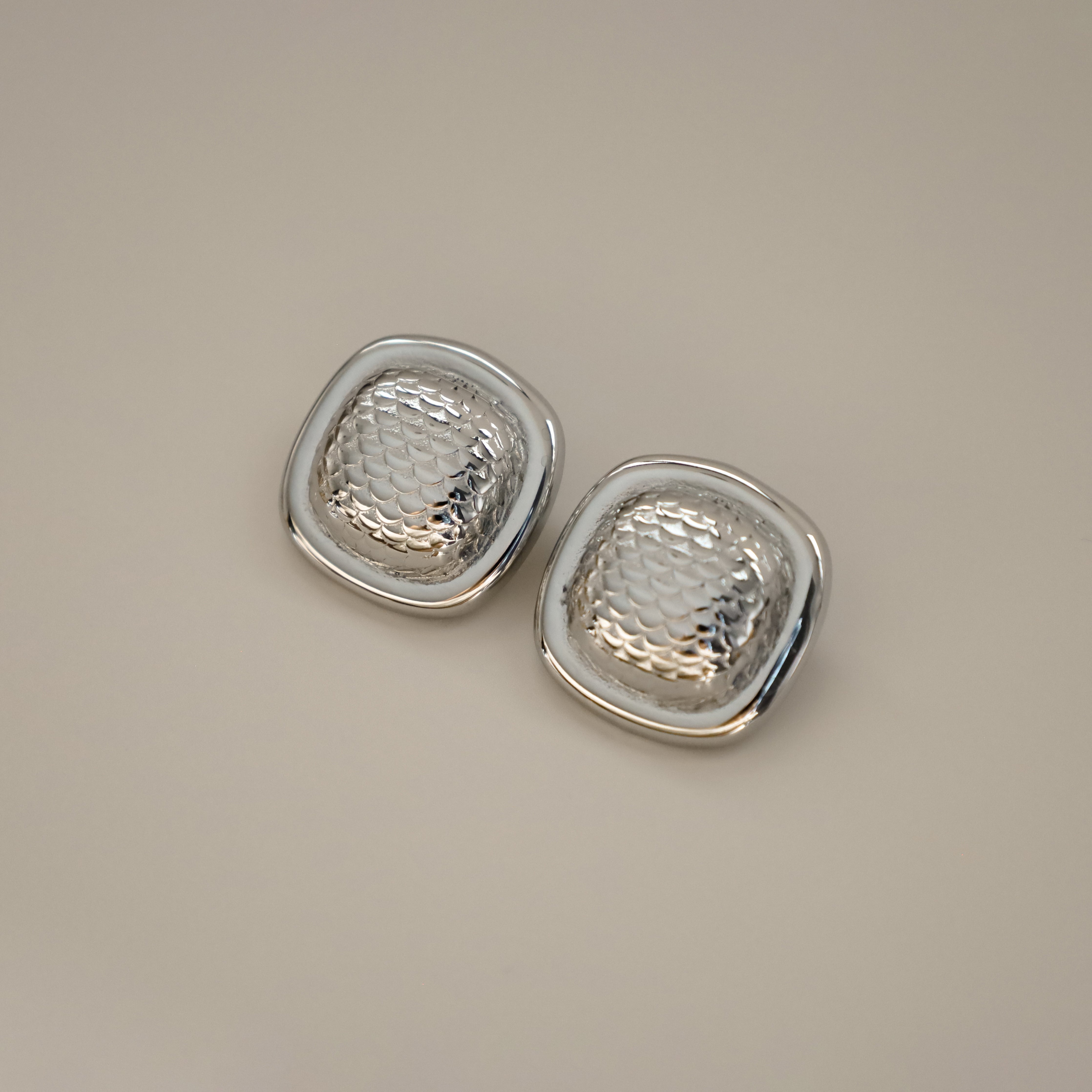 ezana earrings, silver rectangular earrings with puffy center in a scale design and smooth outer edge